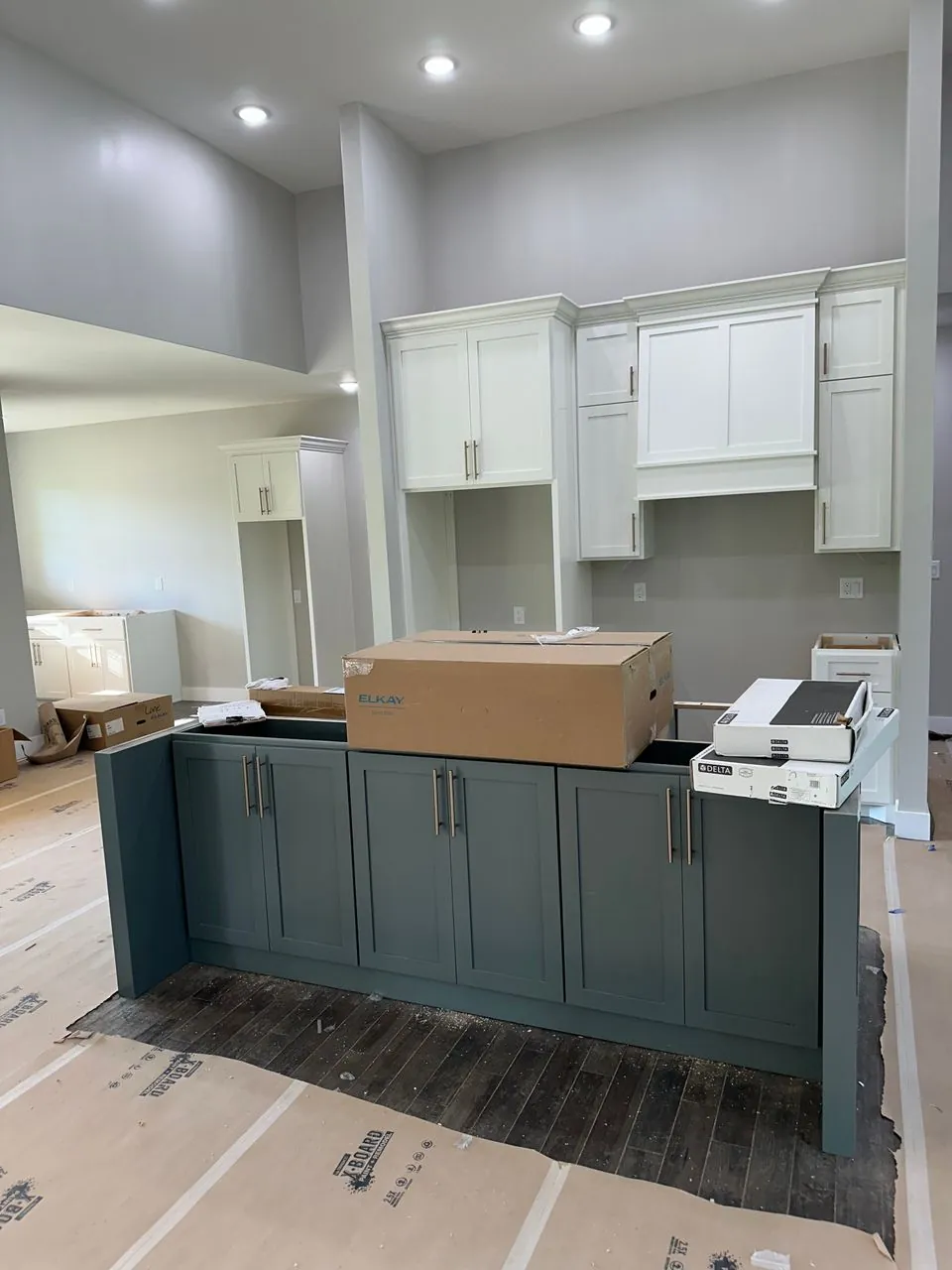 Large fitted cabinetry installation with tall white Shaker cabinets and a charcoal work island